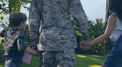 Image of soldier holding kids hands showing the importance of disruptive technologies AM to produce reliable and better performing equipment.